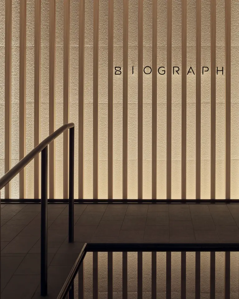 Staircase and wood-slat wall with Biograph lettering at the San Mateo clinic