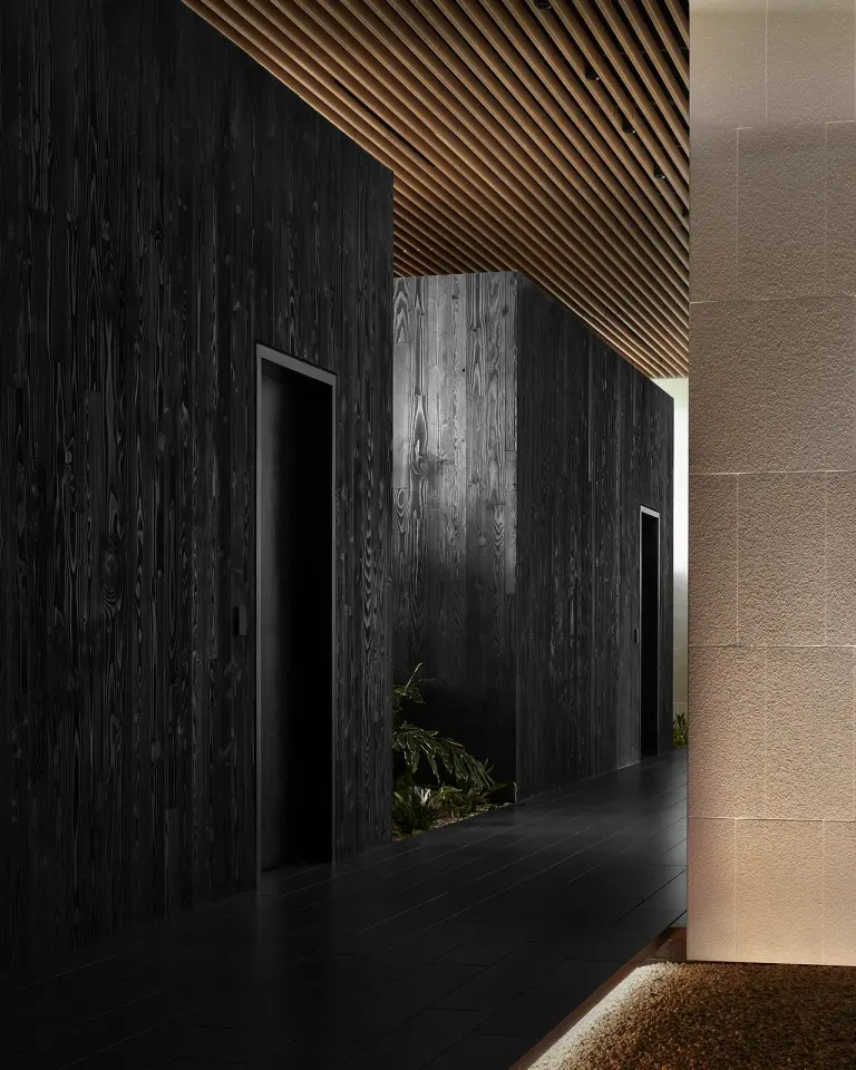 Dark charred-wood corridor with slatted ceiling at Biograph San Mateo