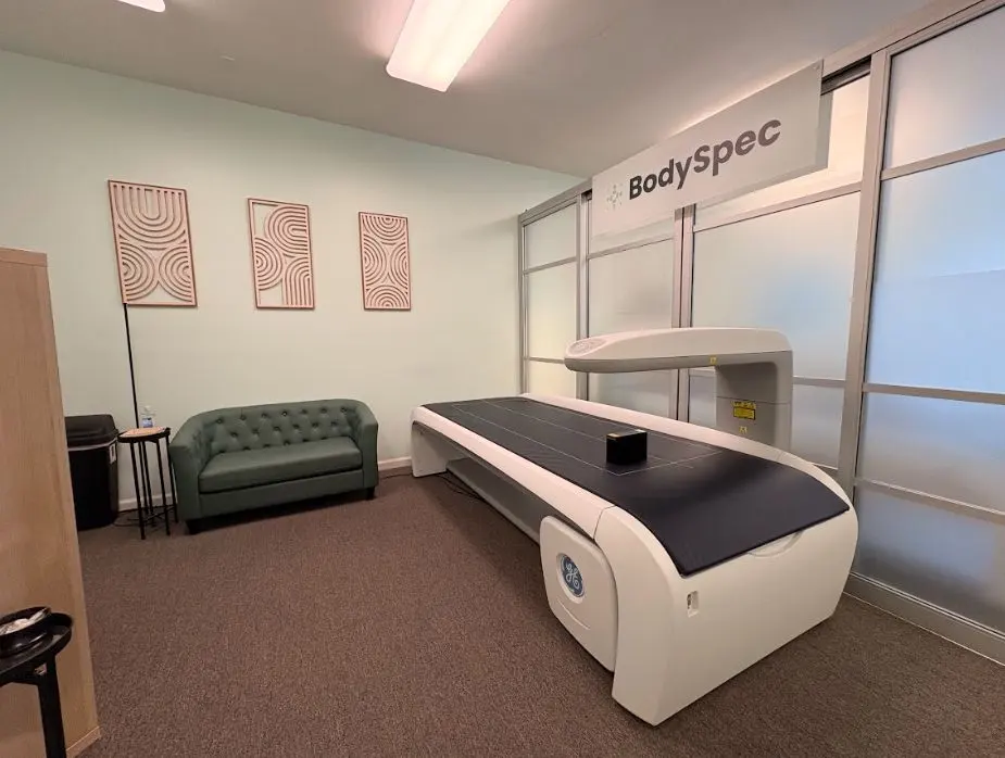Scan room with DEXA table and green sofa at BodySpec Palo Alto