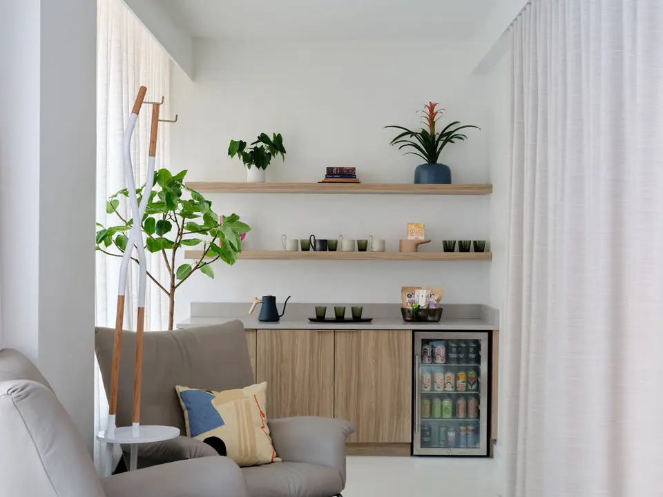 Lounge corner with armchair, plants and a drinks fridge at Clean Market NoHo