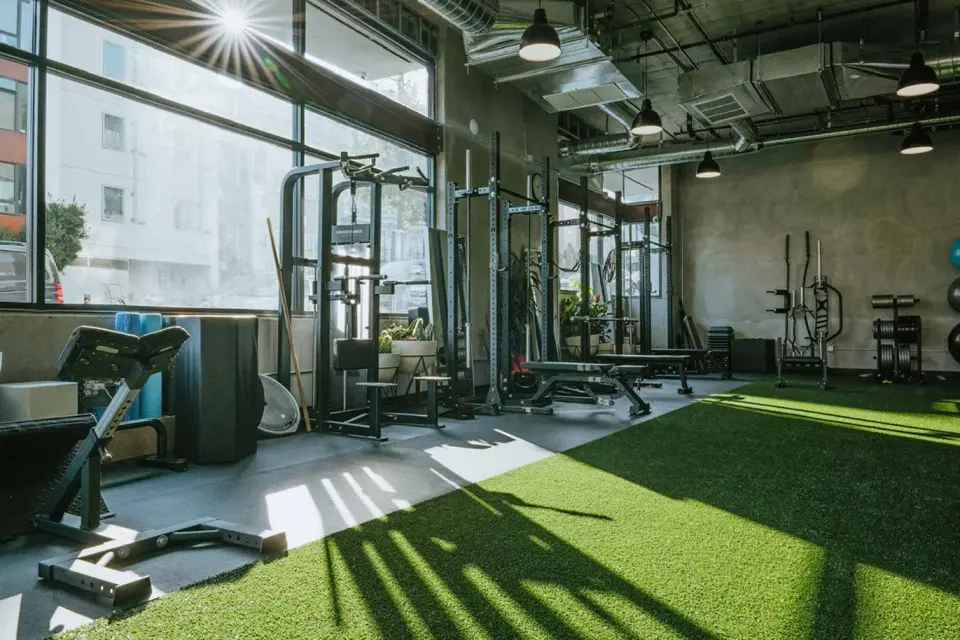 Sunlit training floor with turf and strength equipment at Custom Fit Hayes Valley