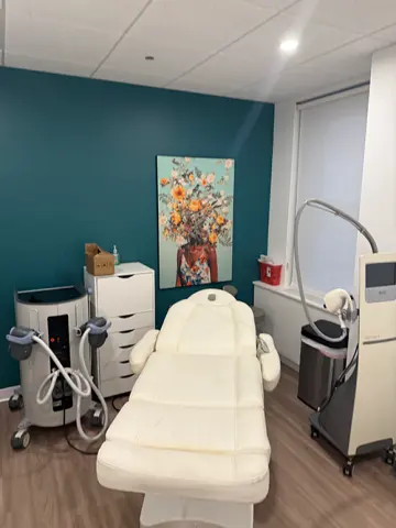 Treatment room with a white procedure chair and body-contouring devices at Dexaslim