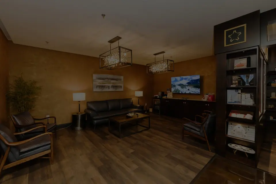 Wide view of the lobby at Executive Medicine of Texas with leather seating, chandeliers and a lit retail cabinet