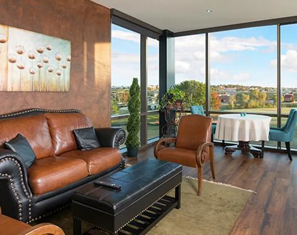 Patient lounge at Executive Medicine of Texas with a leather sofa and floor-to-ceiling windows overlooking Southlake