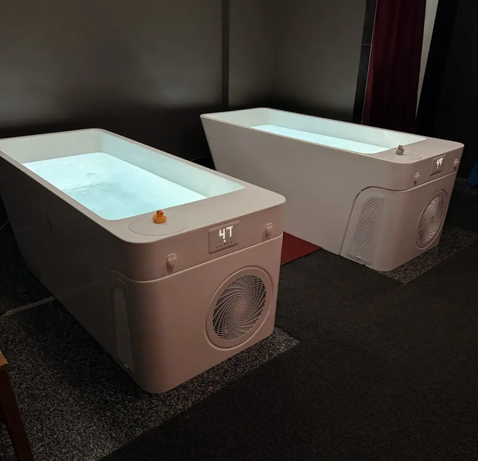 Two white cold plunge tubs in a dark room at Healthspan