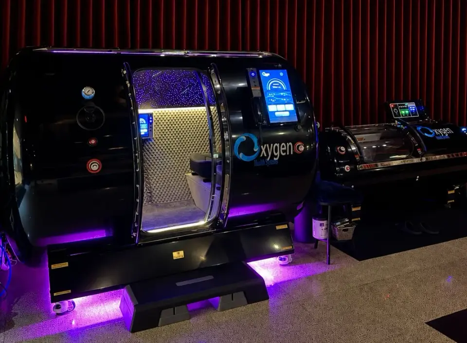 Black hyperbaric oxygen chambers with purple underlighting at Healthspan