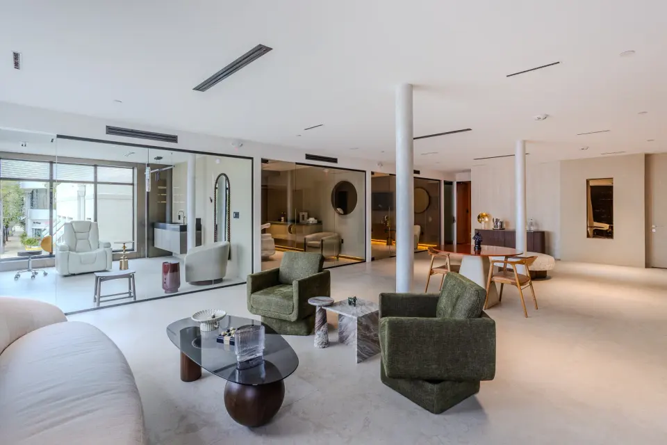Open lounge with armchairs and glass-walled treatment rooms beyond at Healthy Longevity Clinic Miami