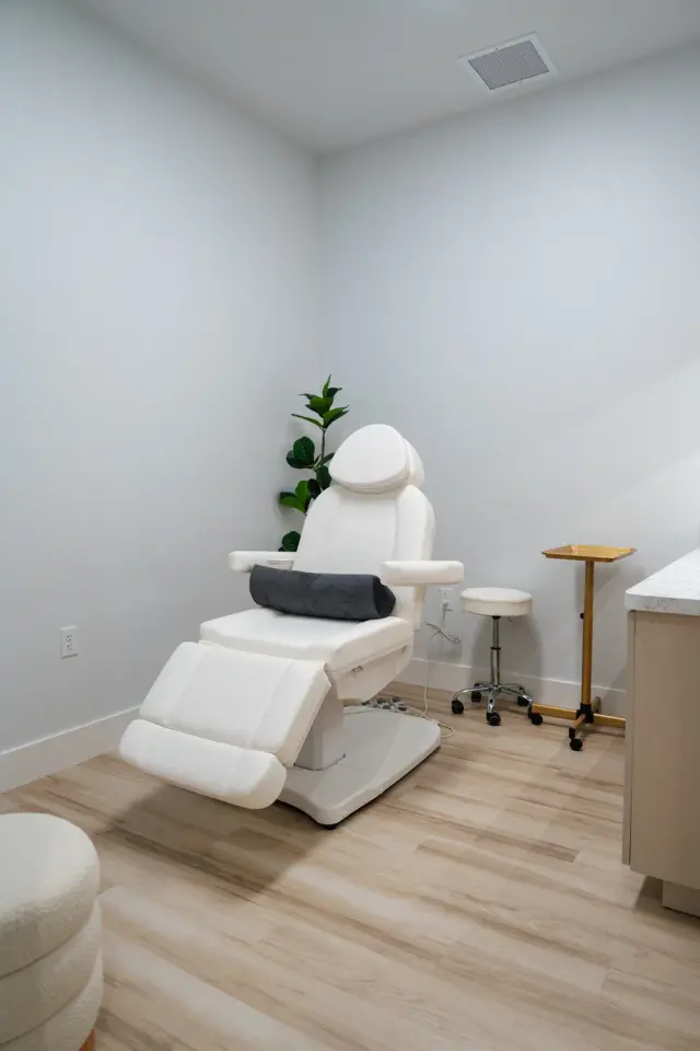 Treatment room at Highland Longevity with a white procedure chair, stool and side cabinet