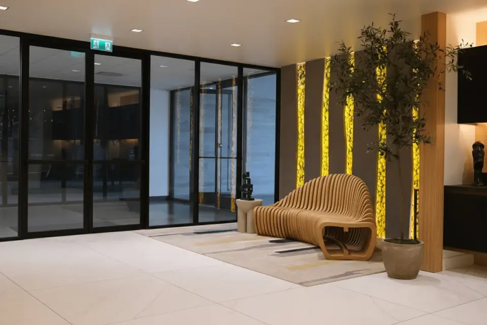Wider view of the lobby, glass doors and sculptural bench at the Human Longevity Bay Area clinic