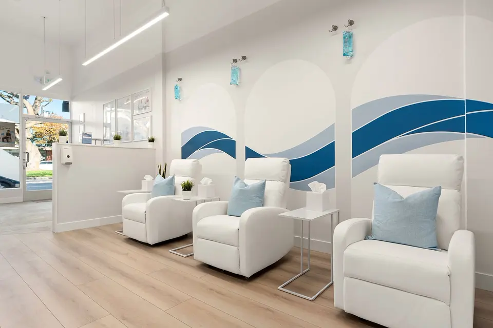 IV lounge with white recliners and blue wave mural at Hydration Room Brentwood