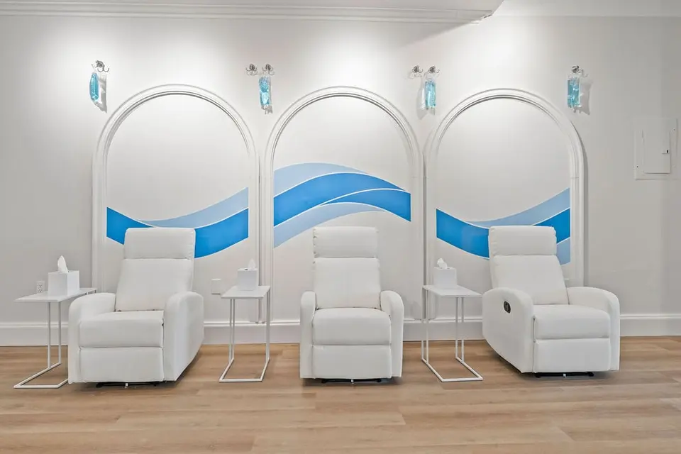 Three white recliners under arched wave murals at Hydration Room Cow Hollow