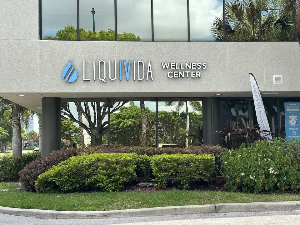 Liquivida Wellness Center signage on the front of the Aventura office building with landscaped hedges