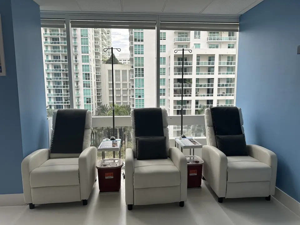 Three IV lounge recliners in front of floor-to-ceiling windows at Liquivida Lounge Brickell