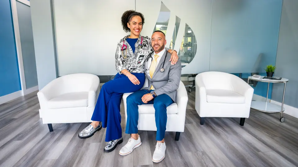 Two Liquivida Wellington team members seated together in the white-chaired lounge