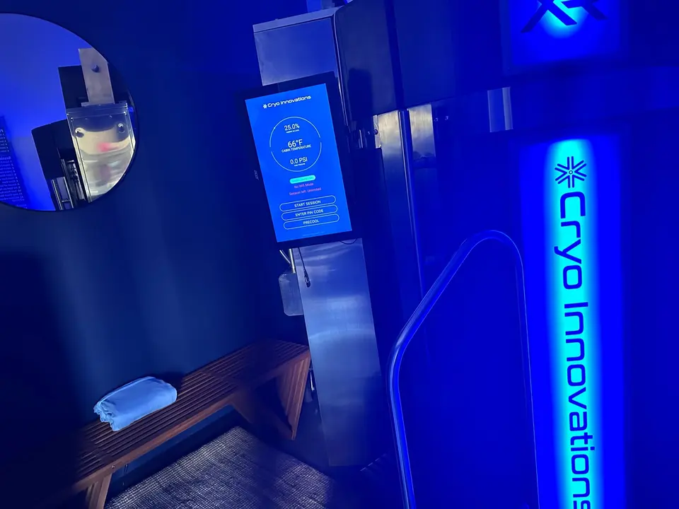 Cryo Innovations cryotherapy chamber lit in blue at Newport Body Works
