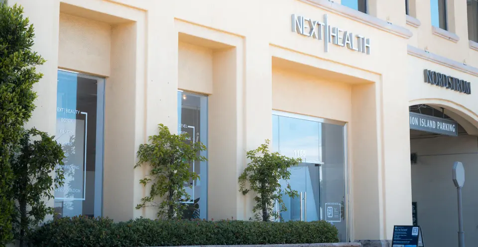 Cream stone facade with Next Health sign in Newport Beach