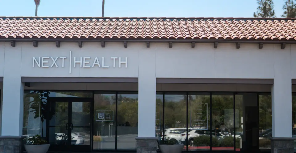 Next Health sign above a tile-roofed storefront in Woodland Hills