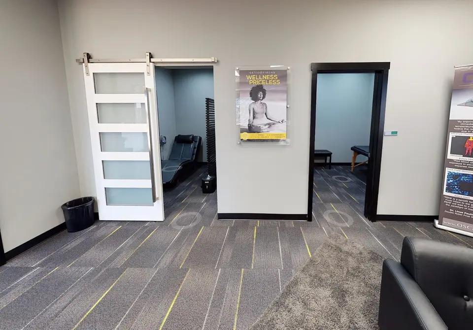 Hallway at OsteoStrong Carrollton with sliding barn doors opening onto private recovery rooms