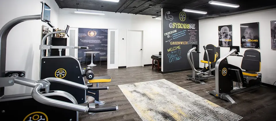 Training floor with OsteoStrong machines and chalkboard wall at OsteoStrong Greenwich