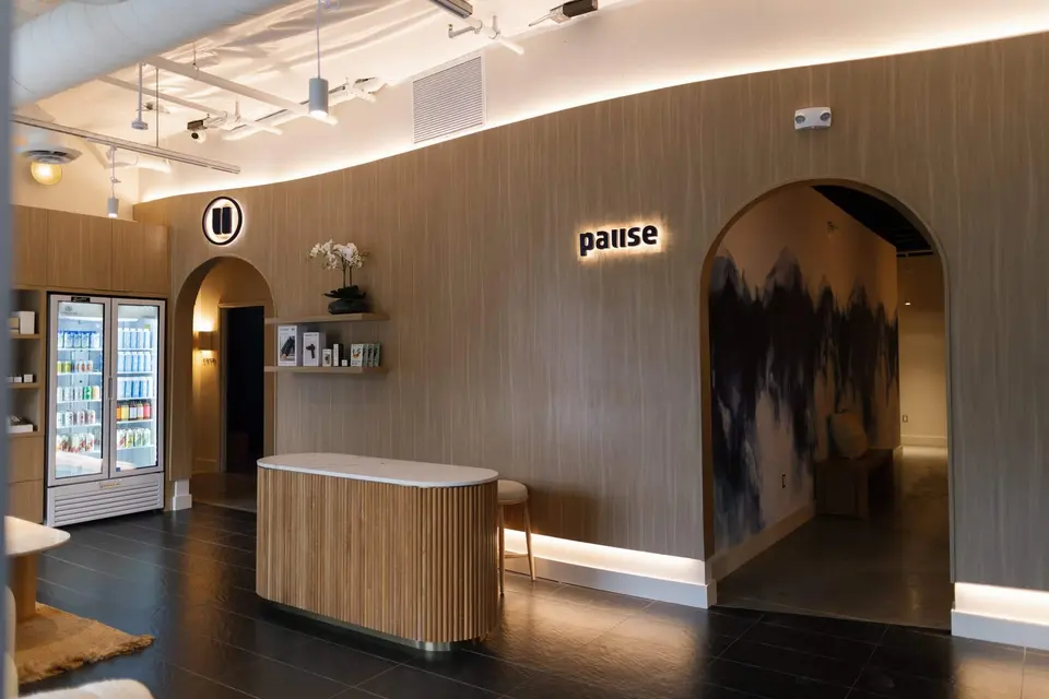 Lobby with arched doorways, reception counter and drinks fridge at Pause Studio Newport Beach