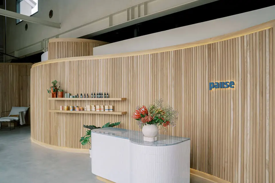 Curved wood-slat wall and reception desk at Pause Studio West Hollywood