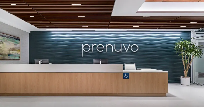 Reception desk in front of the Prenuvo logo wall in Pasadena