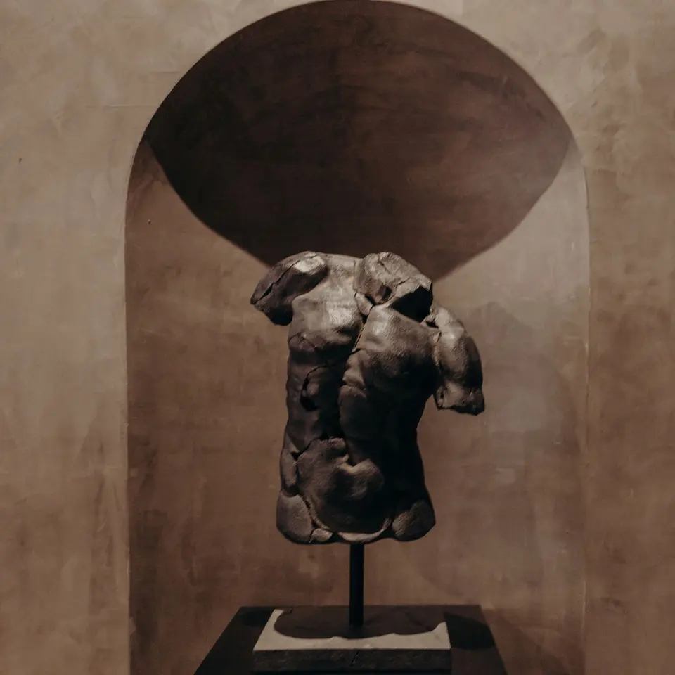 Bronze torso sculpture in a plastered arched niche at Remedy Place Flatiron