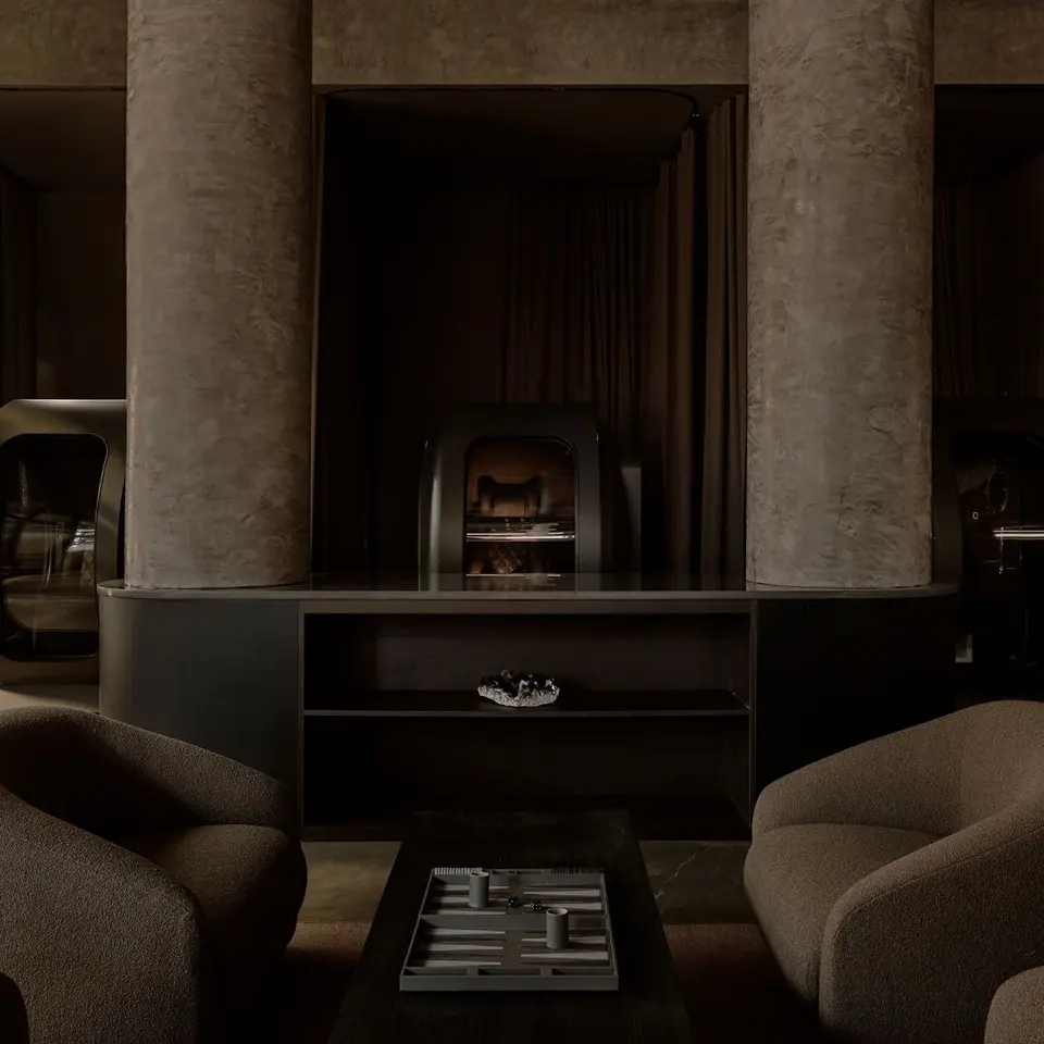Lounge with boucle armchairs, a backgammon table and textured columns at Remedy Place Soho