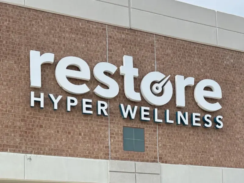 Restore Hyper Wellness sign on the brick facade of the Las Colinas studio