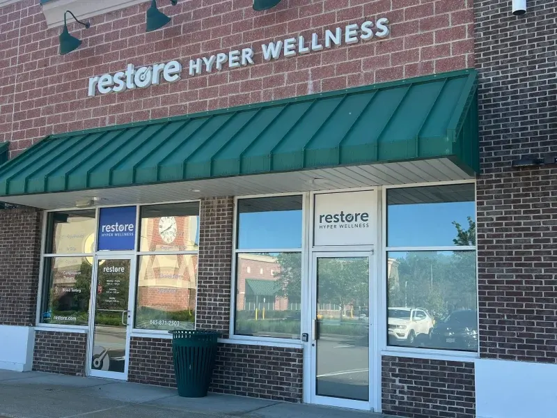 Restore Hyper Wellness storefront with green awning on a brick building in Mt. Kisco