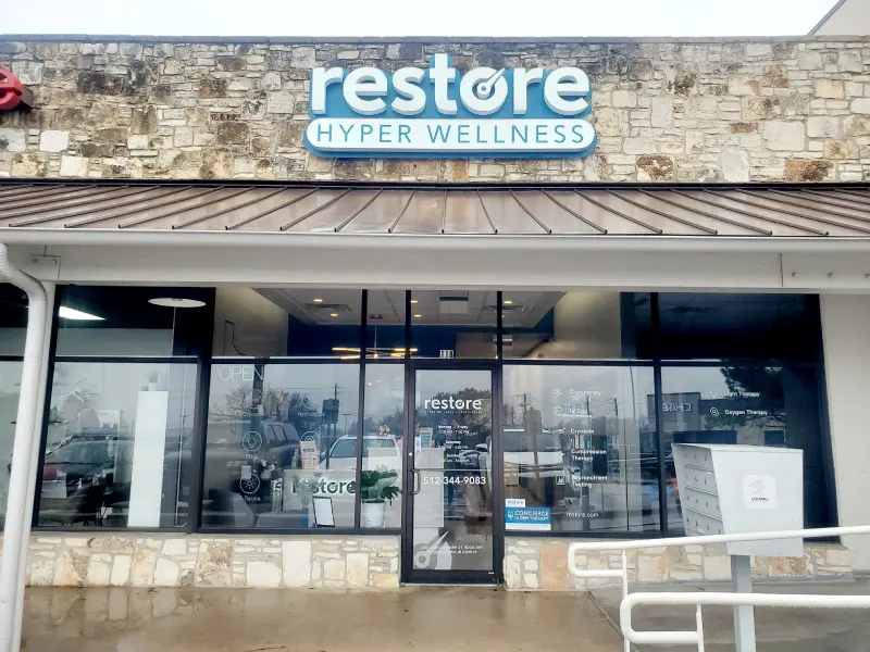 Restore Hyper Wellness storefront with stone facade and metal awning in West Lake Hills
