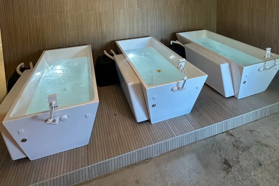 Three white cold plunge tubs on a wooden platform at The Plunge & Sauna Method