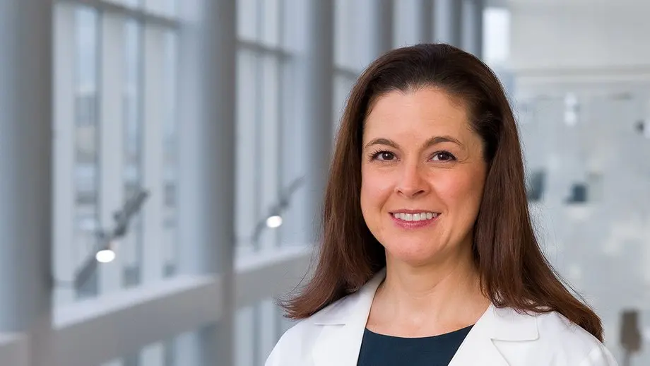 Portrait of Dr. Carey Le Mener of UT Southwestern Executive Health in a white coat, in a bright windowed clinic space